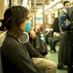 Woman on a train wearing a filter mask