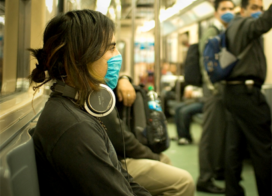Woman on a train wearing a filter mask