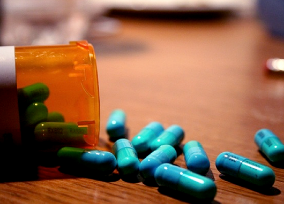 A medicine bottle with pills spilling out